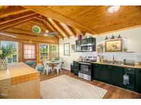 A full view of the kitchen with stainless steel appliances, and a unique wooden ceiling at 2508 Albany St, Durham, NC 27705