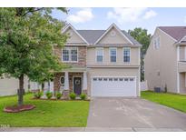 Charming two-story home featuring stone accents, a welcoming front porch, and a well-maintained lawn at 3019 Britmass Dr, Raleigh, NC 27616