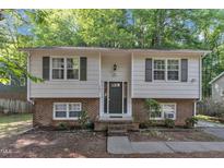 Charming two-story home with light siding, brick accents, and symmetrical windows and shutters at 309 Penn Oak Cir, Raleigh, NC 27615