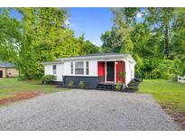 Charming renovated single-story home features a red accent wall and updated landscaping at 313 W Church St, Angier, NC 27501