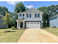 Charming two-story home featuring a two-car garage, stone accents, and a well-manicured lawn, perfect for suburban living at 315 New Twin Branch Ct, Smithfield, NC 27577