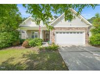 Charming home featuring stone accents, a two-car garage, manicured landscaping, and a welcoming front porch at 320 Trout Valley Rd, Wake Forest, NC 27587