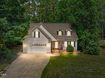 Charming home featuring a manicured lawn, two-car garage, and inviting brick-lined front porch at 347 Manchester Trl, Clayton, NC 27527