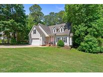 Charming home with a well-manicured lawn, attached garage and mature trees at 347 Manchester Trl, Clayton, NC 27527