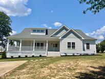 Charming home with a covered front porch, dormer windows, and a well-maintained lawn at 4016 Berman Edge Rd, Holly Springs, NC 27540