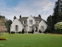 Stunning two-story home featuring a brick and stone facade, lush lawn, and inviting entrance at 404 Shinleaf Pond Trl, Raleigh, NC 27614