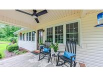 Inviting front porch with ceiling fan and rocking chairs; perfect for relaxing outdoors at 41 Maple Cir, Pittsboro, NC 27312