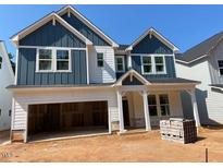 Charming new construction home featuring a two-car garage, blue siding and white trim at 452 Golden Dragonfly St, Wake Forest, NC 27587