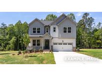 Charming two-story home with attached garage, landscaped front yard, and inviting front porch at 452 Golden Dragonfly St, Wake Forest, NC 27587