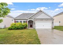 Charming single-story home featuring manicured landscaping and a two-car garage at 57 S Great White Way, Clayton, NC 27527