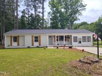 Charming white brick ranch-style home with wooden shutters and a well-maintained lawn at 623 Glenwood Dr, Sanford, NC 27330