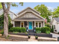 Charming home with gray siding, shingle detail, blue door, and well-manicured landscaping at 711 Hinsdale St, Raleigh, NC 27605