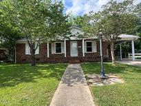 Charming brick home with well-maintained lawn and a covered parking area at 727 Queens Ave, Dunn, NC 28334