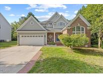 Charming front exterior featuring a brick and siding facade, well-manicured lawn, and inviting curb appeal at 8517 Evans Mill Pl, Raleigh, NC 27613