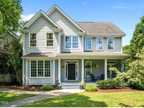 Charming two-story home featuring a welcoming front porch and beautifully landscaped front yard under a clear blue sky at 100 Michaels Way, Chapel Hill, NC 27516