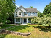 Charming two-story home with a well-manicured lawn, stone wall, and inviting front porch at 100 Michaels Way, Chapel Hill, NC 27516