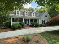 Charming home with a manicured lawn, inviting front porch, and well-maintained landscaping at 1009 Bearglades Ln, Raleigh, NC 27615