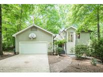 Charming home exterior with a basketball hoop above the garage, surrounded by mature trees at 103 Harrington Pt, Chapel Hill, NC 27516