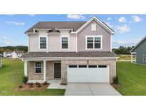 Charming two-story home with a brick facade and a two-car garage at 109 Gladstone Loop, Clayton, NC 27520