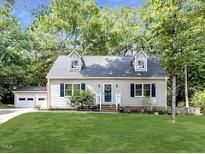Charming one story home with manicured lawn, dormer windows, and a detached two car garage at 113 Honeysuckle Ln, Durham, NC 27703
