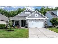 Charming single-Gathering home featuring a stone facade, a two-car garage, and a cozy front porch at 120 Bramble Ln, Clayton, NC 27527