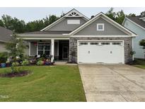 Charming single-story home featuring a well-manicured lawn and a welcoming covered front porch at 120 Bramble Ln, Clayton, NC 27527