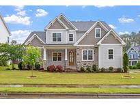 Charming two-story home featuring stone accents, manicured lawn and mature landscaping at 122 Swansboro Ln, Chapel Hill, NC 27516