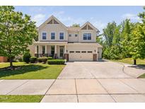 Charming two-story home featuring a manicured lawn, attached two-car garage, and inviting front porch at 1458 Wragby Ln, Apex, NC 27502