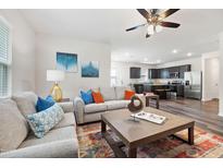 Open concept living room featuring hardwood floors and view into the kitchen with stainless steel appliances at 1512 Arapahoe Ridge Dr, Raleigh, NC 27604