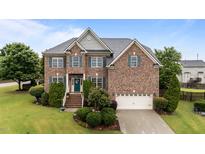Charming brick home with green shutters, a two-car garage, manicured lawn, and a welcoming entrance at 19 Arch Oak Ct, Clayton, NC 27527