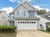 Charming two-story home with gray siding, white trim, blue shutters, and a two-car garage at 1928 Shadow Glen Dr, Raleigh, NC 27604