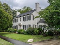 Charming two-story home with a well-manicured lawn and mature trees at 1930 Reid St, Raleigh, NC 27608