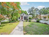 Charming home featuring a landscaped front yard, a walkway, and a vibrant red front door at 2209 The Circle, Raleigh, NC 27608