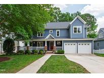 Charming two-story home with a well-manicured lawn, large front porch, and a two-car garage at 2309 Filigree Ct, Raleigh, NC 27614