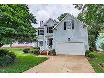 Charming home featuring a two-car garage, landscaped yard, and a welcoming front porch at 2441 Deanwood Dr, Raleigh, NC 27615