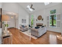 Bright living room with hardwood floors, fireplace, and large windows with white shutters at 3 Yancey, Pittsboro, NC 27312