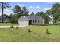 Charming home featuring a well-manicured lawn, attached garage, and inviting curb appeal at 30 Cornerstone Dr, Franklinton, NC 27525