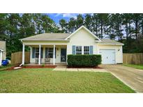Charming single-story home with a well-manicured lawn, cozy front porch with rocking chairs, and attached one car garage at 3709 Fan Palm Ct, Raleigh, NC 27616