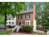 Charming two-story brick home with white trim and lush green landscaping at 4 Weathergreen Ct, Durham, NC 27713