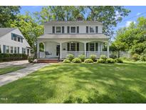 Charming two-story home featuring a welcoming front porch, lush lawn, and mature trees offering curb appeal at 406 E Lee St, Smithfield, NC 27577