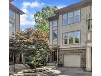 Beautiful townhome featuring stone accents, a garage, manicured landscaping, and an inviting entrance at 4802 Glenmist Ct, Raleigh, NC 27612