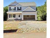New two-story home featuring light-gray siding, black shutters, an attached garage and a front porch at 50 Moonraker Dr, Spring Hope, NC 27882