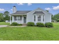 Charming home with a well-maintained lawn, inviting porch, and a classic bay window at 5849 Rocking Chair Dr, Youngsville, NC 27596