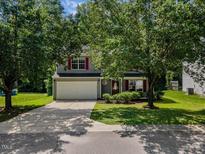 Charming two-story home with a well-manicured lawn, a two-car garage, and traditional architectural details at 5940 Brambleton Ave, Raleigh, NC 27610