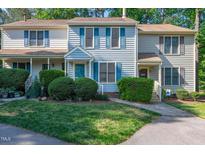 Charming townhome featuring a manicured lawn, flowering shrubs, and a lovely blue accent color at 6513 Hearthstone Dr, Raleigh, NC 27615