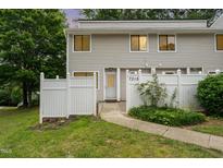 Charming townhouse with a white picket fence and landscaped front yard at 7315 Sandy Creek Dr # 7, Raleigh, NC 27615