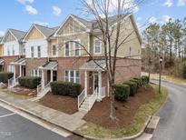 Attractive townhome with a brick facade, a landscaped front yard, and a private entrance with bright white railings at 763 Blossom Grove Dr, Cary, NC 27519