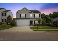 Charming two-story home with gray siding, white trim, attached garage, and a well-maintained front lawn at 8008 Bright Oak Trl, Raleigh, NC 27616