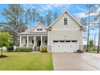 Charming home featuring a covered front porch, two-car garage, and manicured lawn at 813 Whitley Way, Wendell, NC 27591