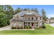 Stately two-story brick home boasts a covered front porch and professionally landscaped yard at 10 Stillwood Ct, Clayton, NC 27520